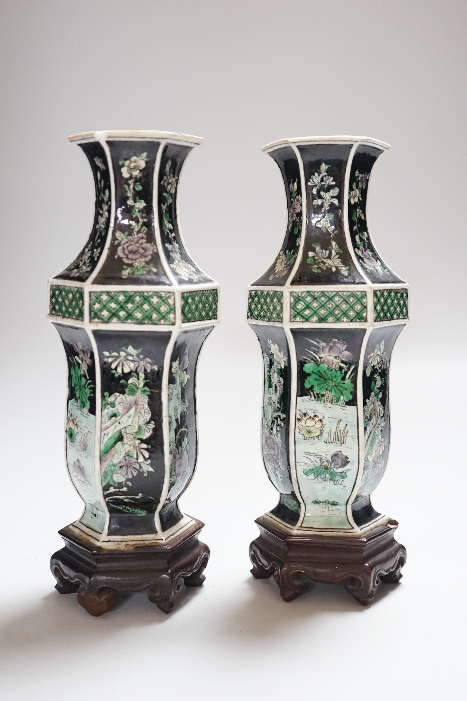 A pair of Chinese famille noire hexagonal vases, late 19th century, wood stands, 21cms high including stands